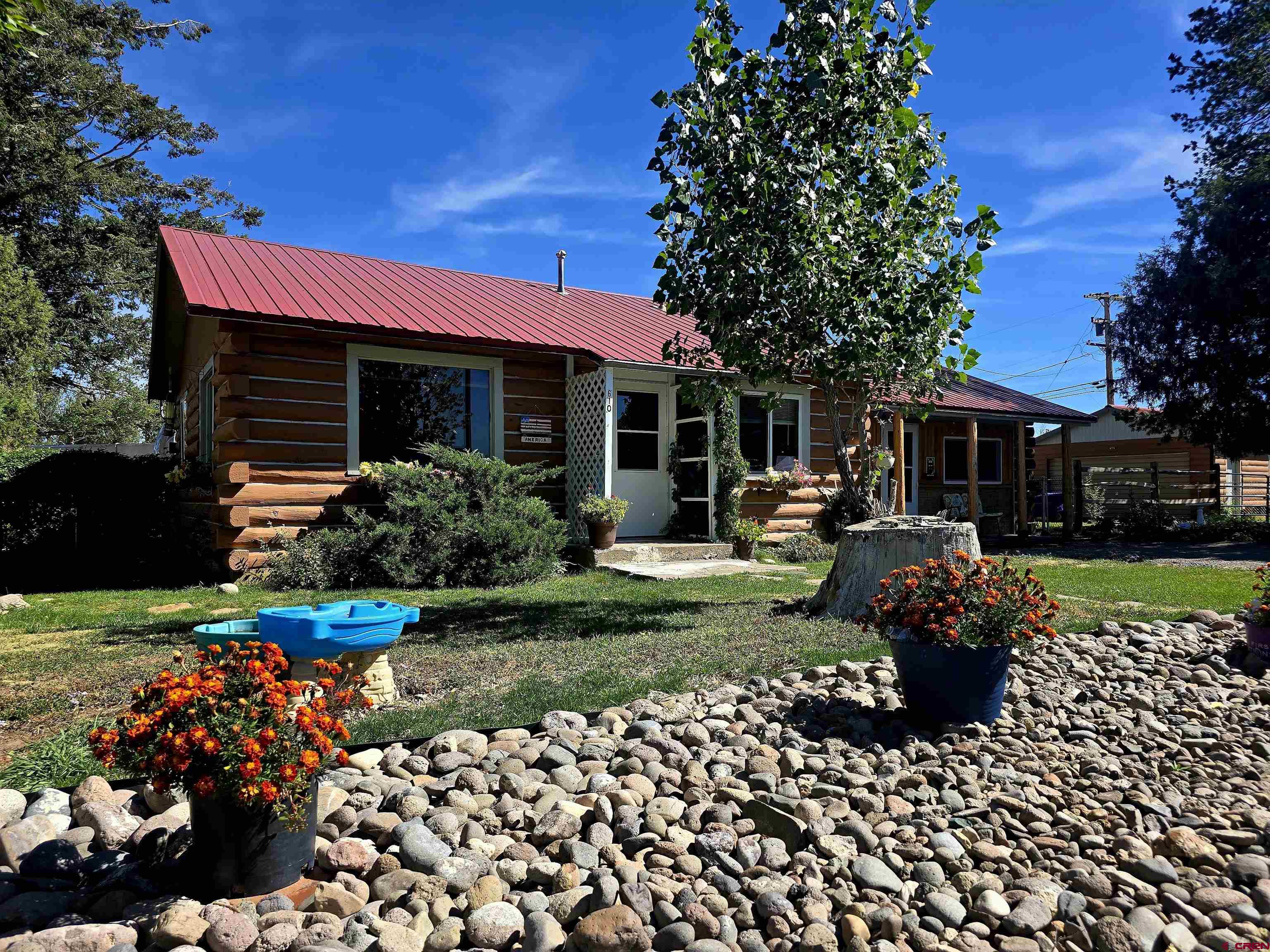 a front view of a house with a yard and a garden