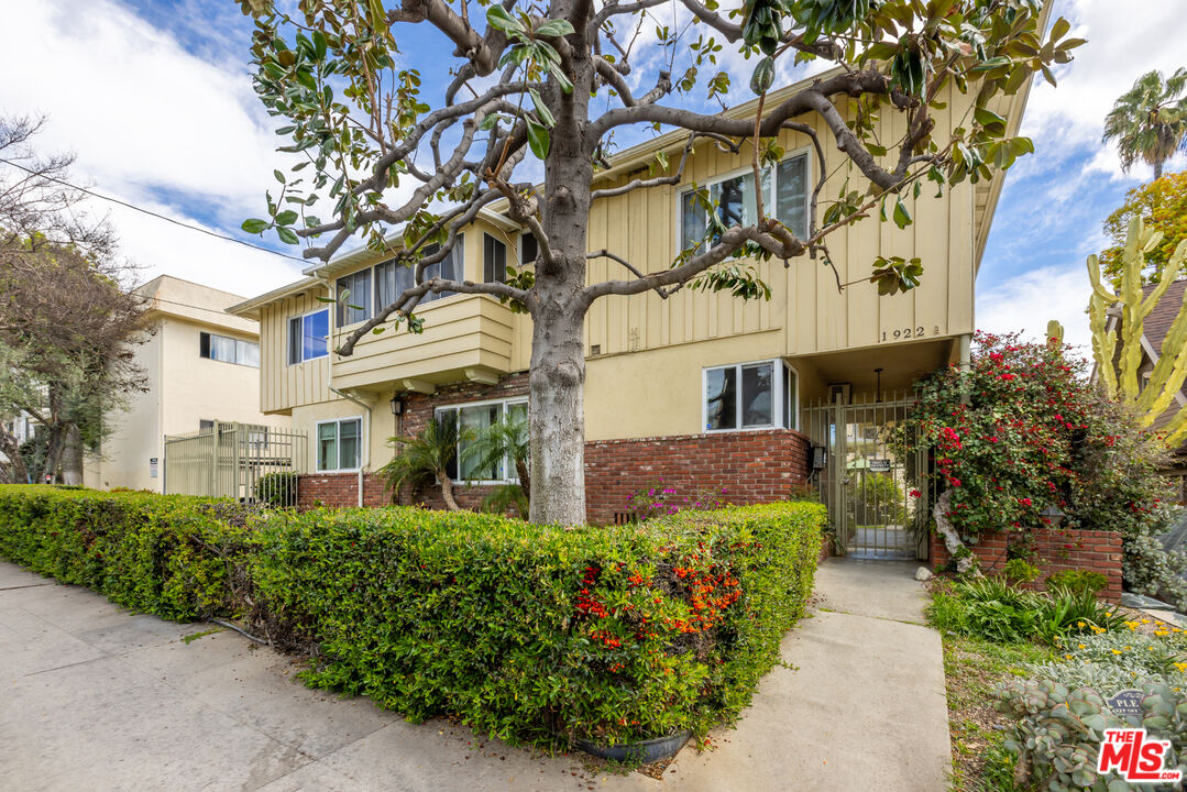 a front view of a multi story residential apartment building with yard and sign board