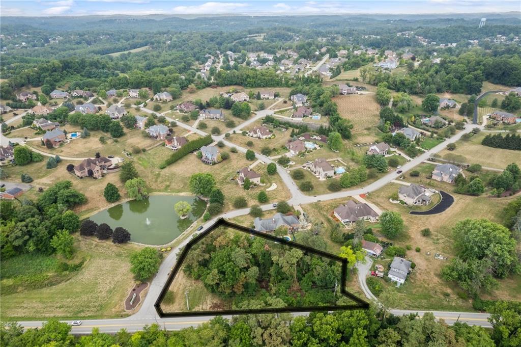 an aerial view of residential houses with outdoor space and trees