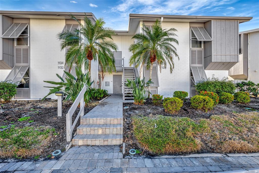 a couple of palm trees in front of yellow house