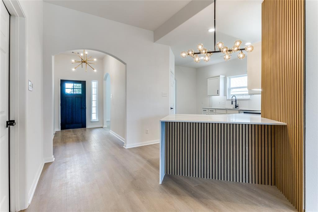 a view of a room with a chandelier and wooden floor