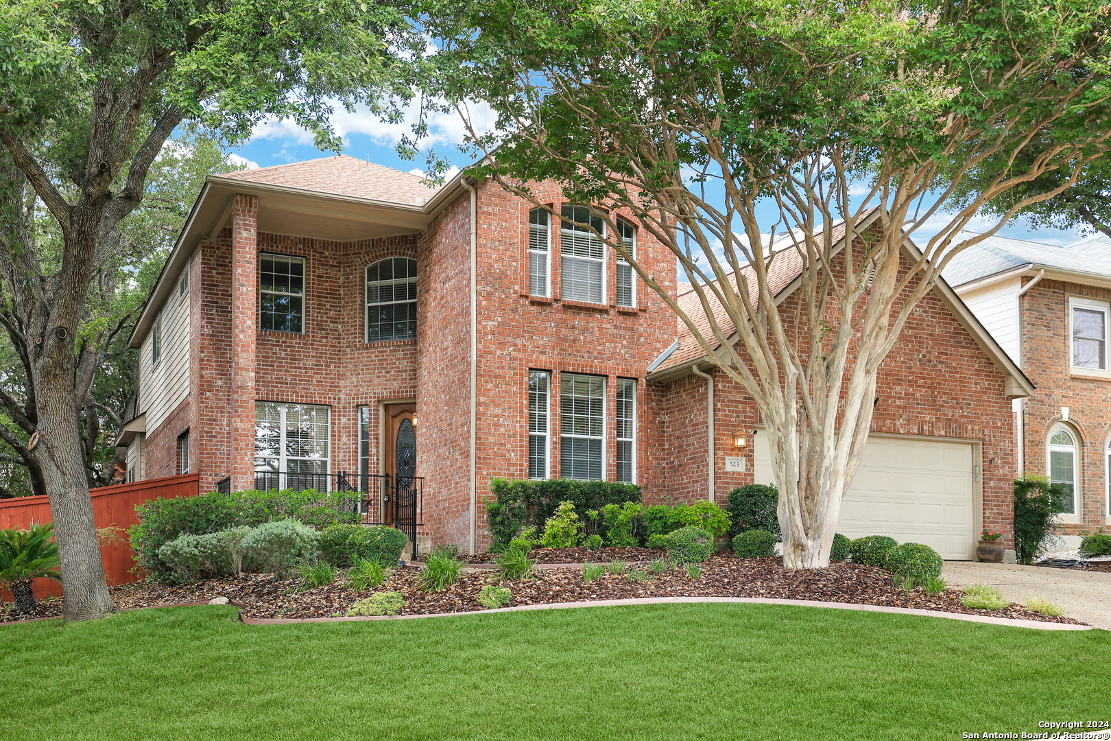 a front view of a house with a yard and trees