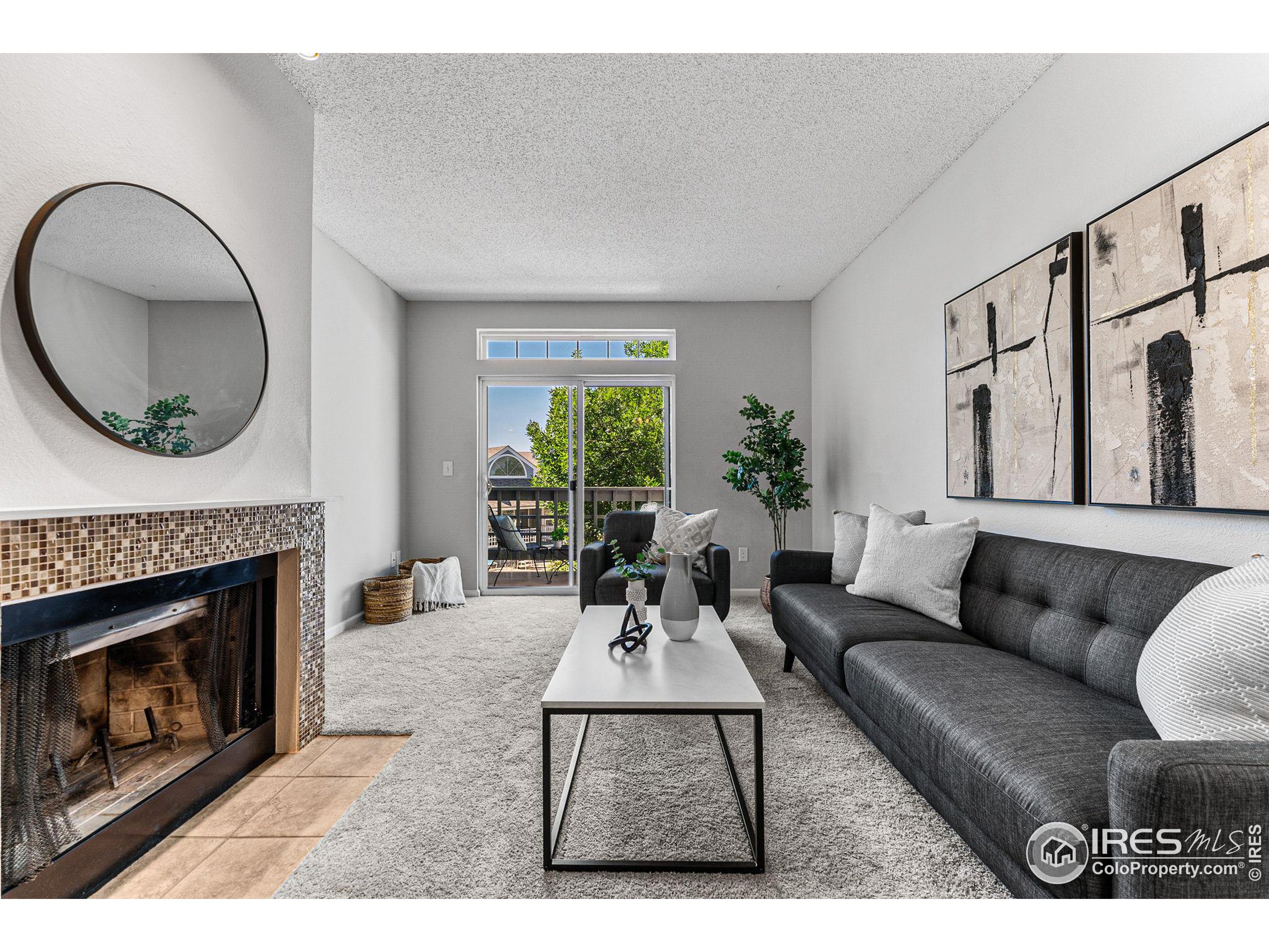 a living room with furniture a fireplace and a large window