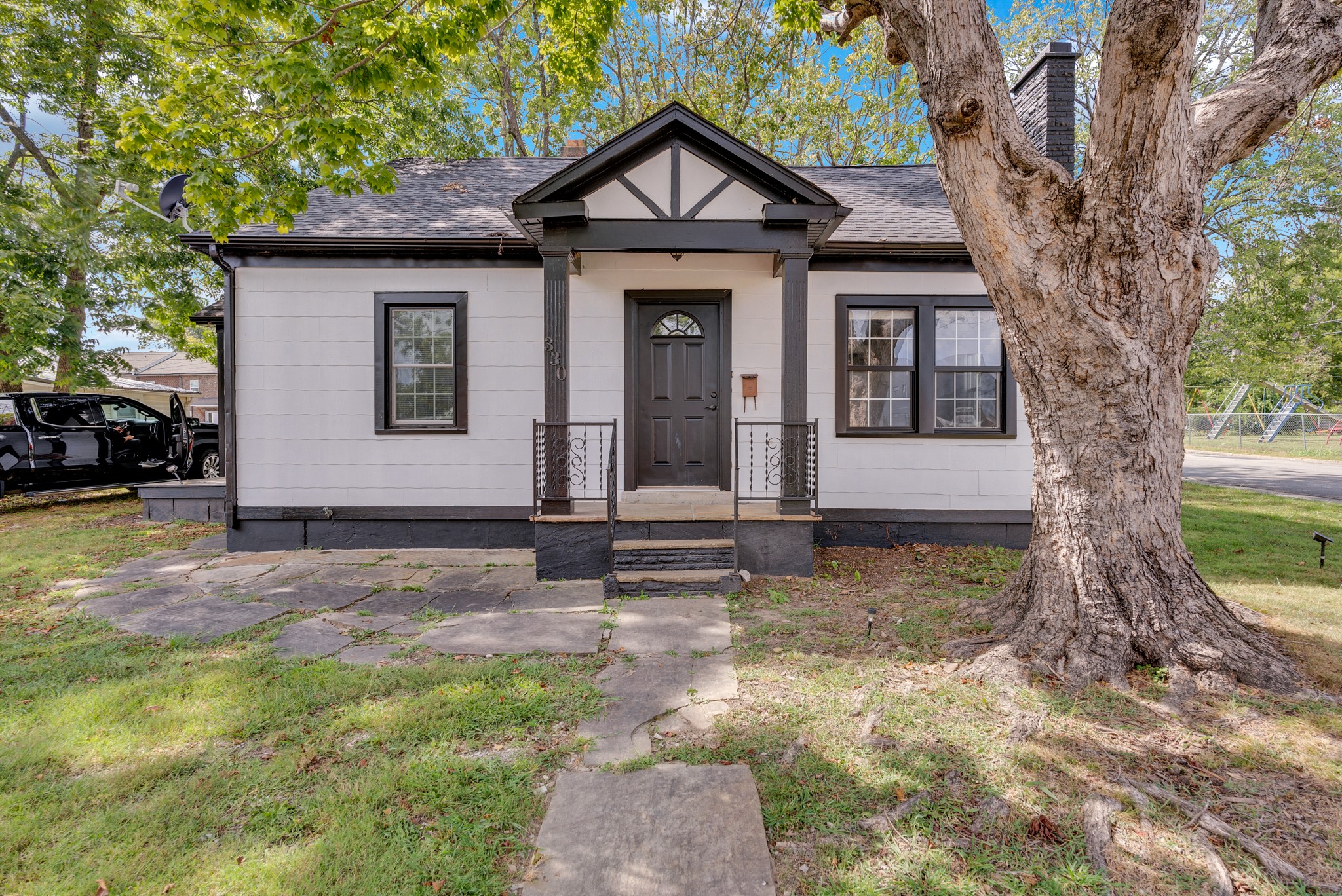 a view of a house with a tree in the yard