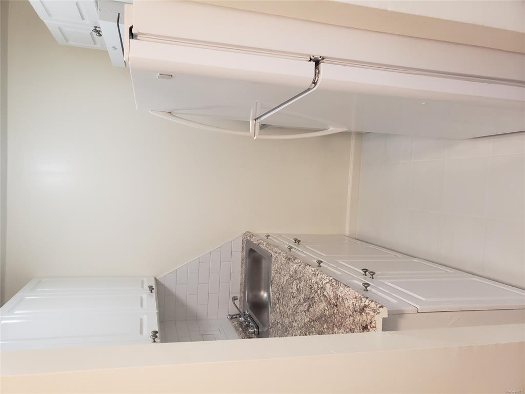 a bathroom with a granite countertop shower and a sink