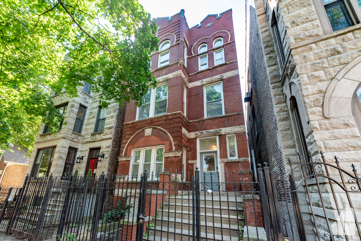 a front view of a residential apartment building with a yard