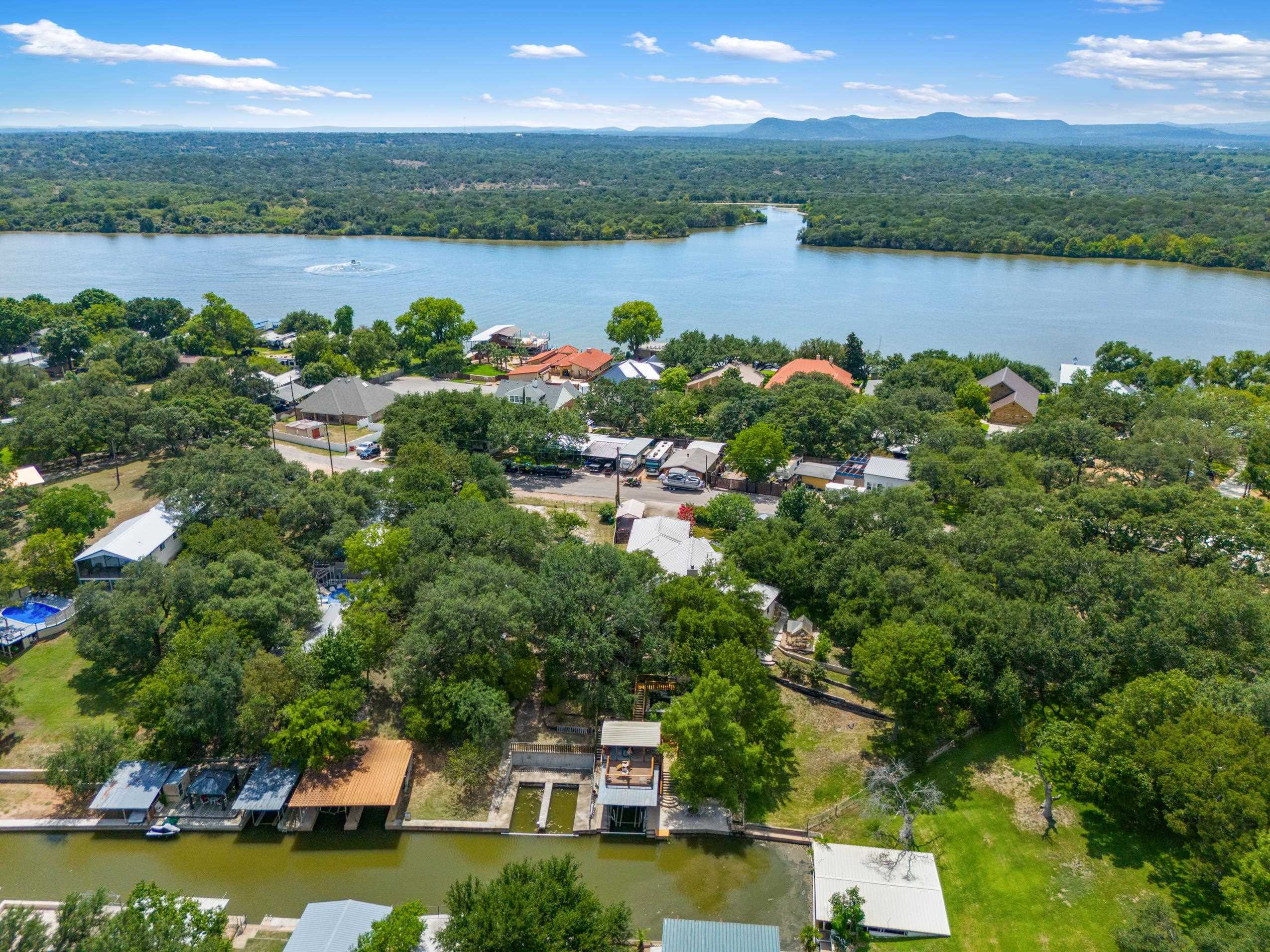 an aerial view of residential houses with outdoor space and lake view