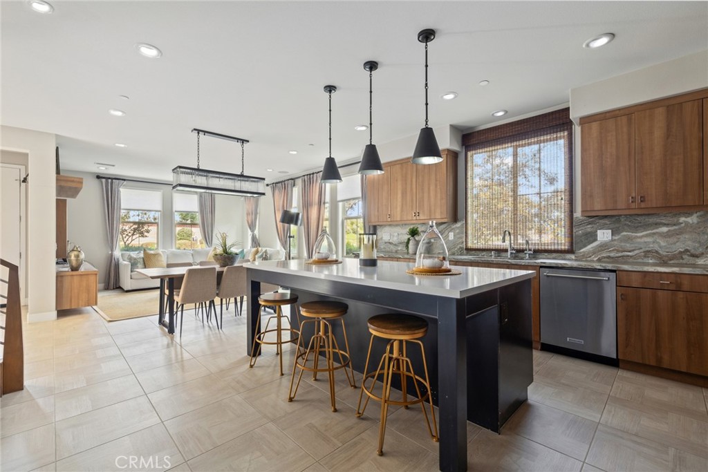 a kitchen island with a dining table chairs sink and cabinets