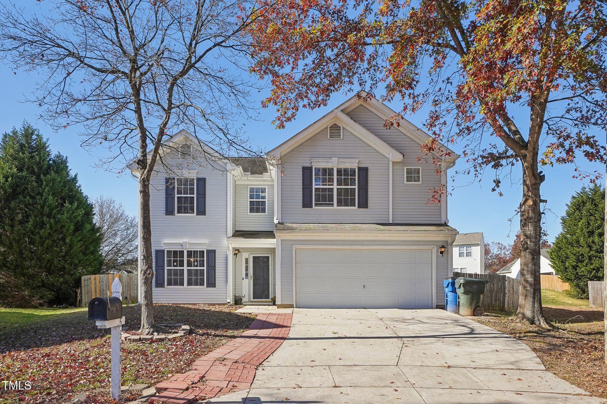 a front view of a house with a yard and trees