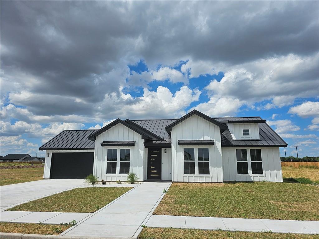 Modern farmhouse style home featuring a garage and a front yard