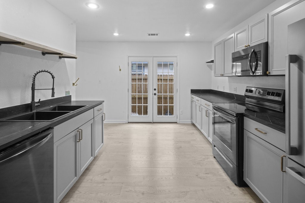 a kitchen with stainless steel appliances granite countertop a stove and a sink