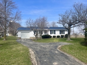 a front view of a house with a yard and trees