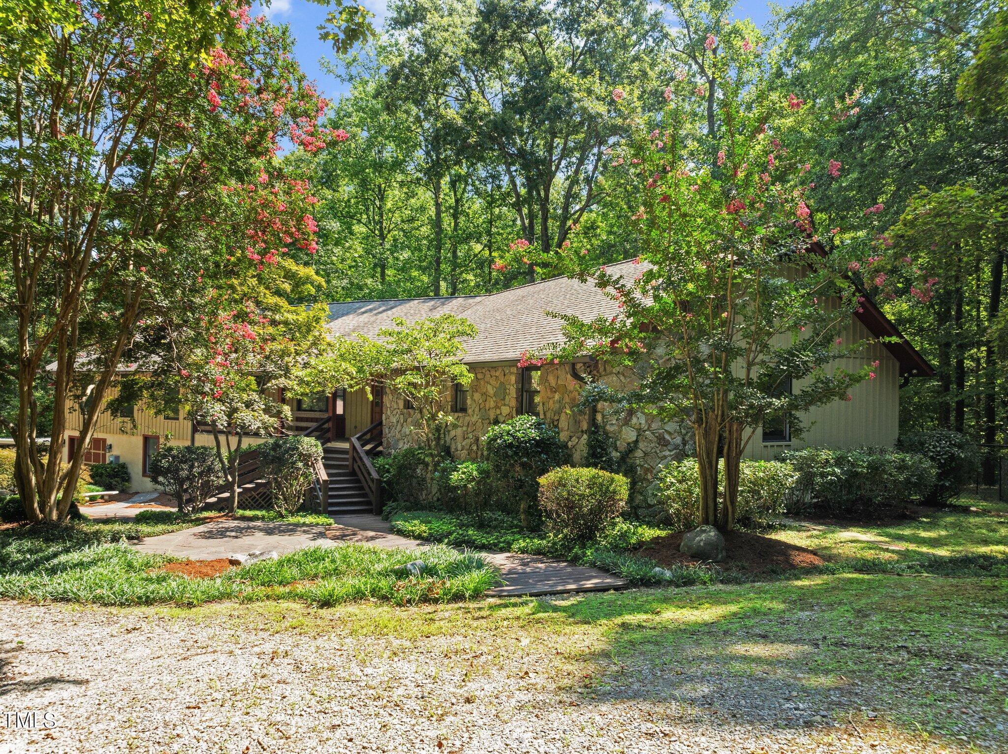 a backyard of a house with a fountain and large trees