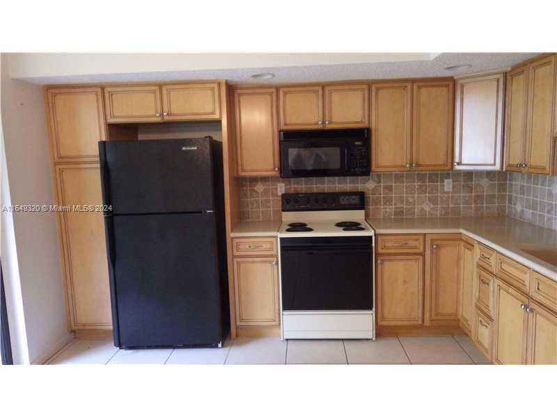 a kitchen with a refrigerator stove and microwave