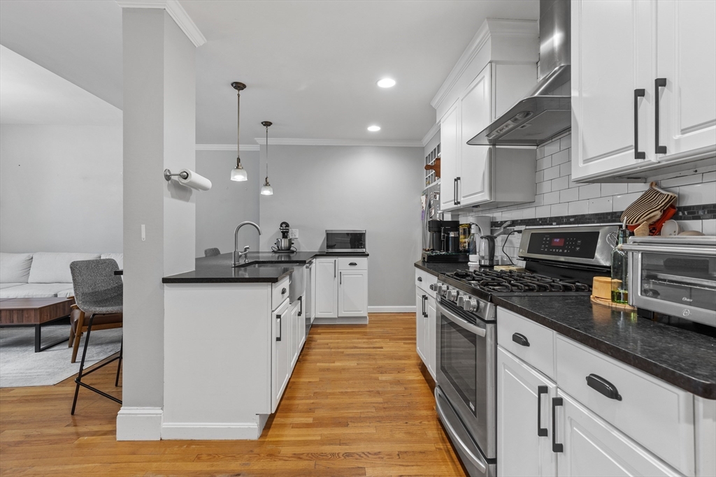 a kitchen with stainless steel appliances granite countertop a stove a sink and a refrigerator