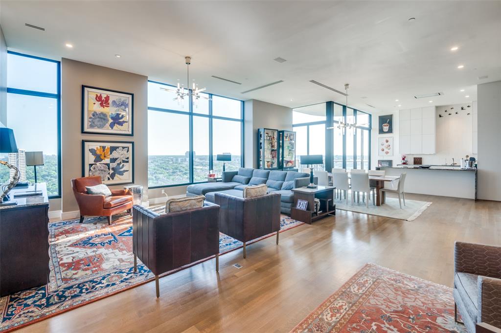 a living room with furniture large window and wooden floor