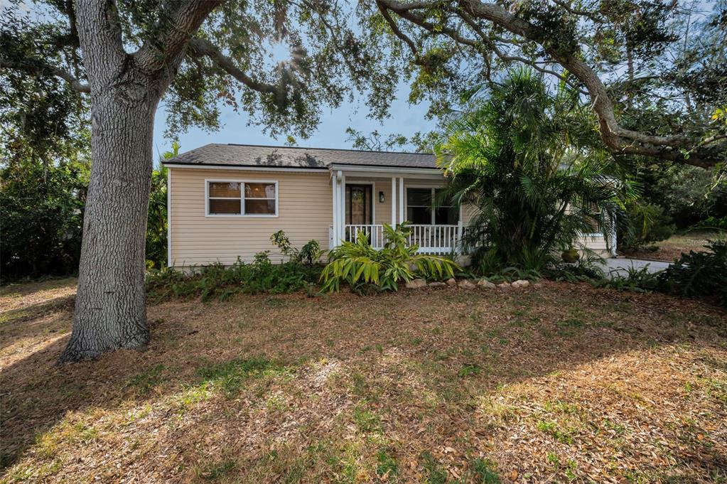 a view of a house with a tree in front of it