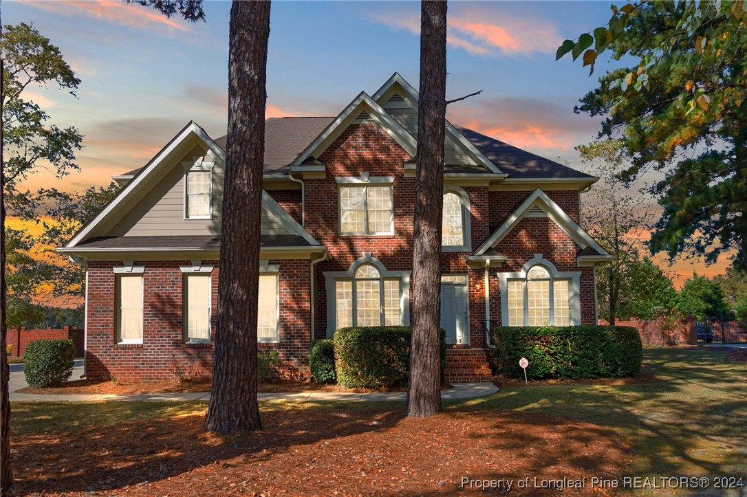 a view of a brick house next to a yard