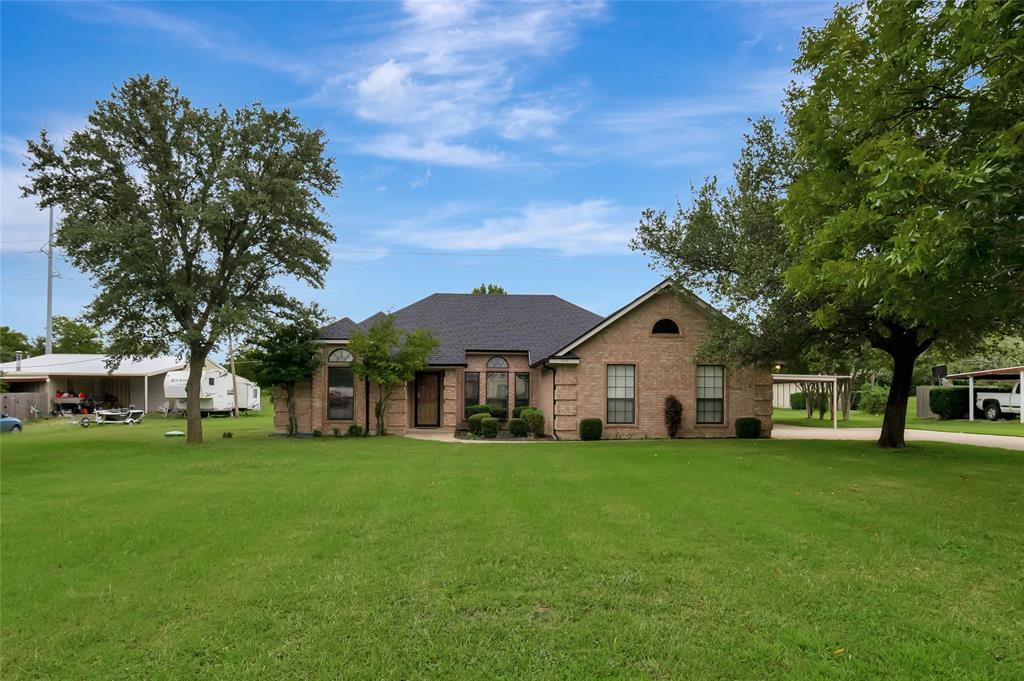 a view of a house with a big yard and large trees