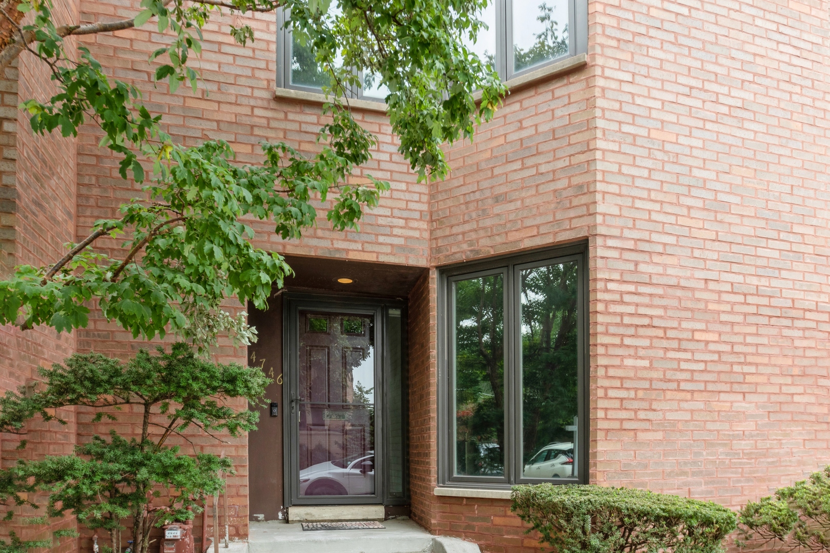 a view of a brick house with potted plants