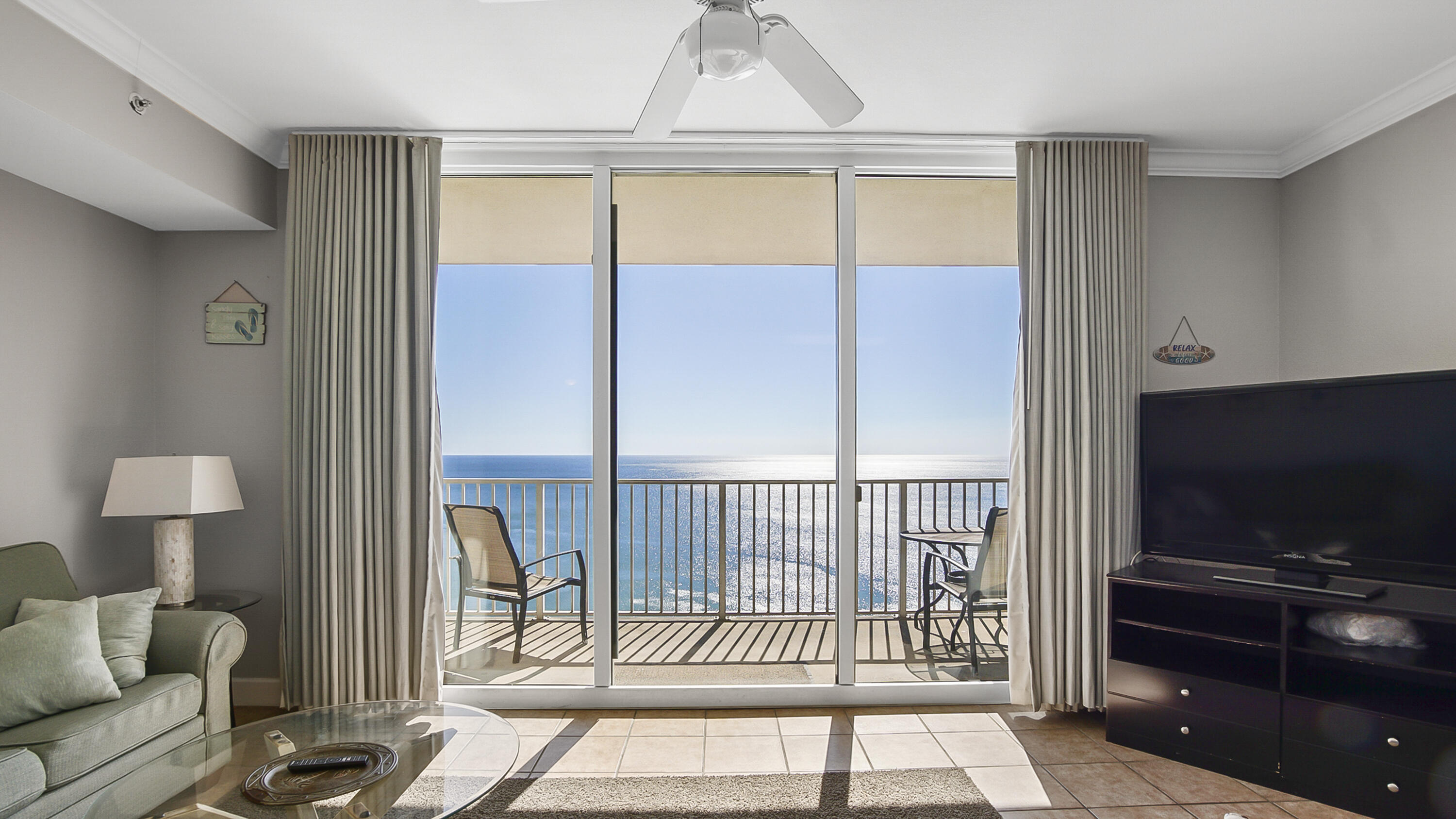 a living room with a flat screen tv and a floor to ceiling window