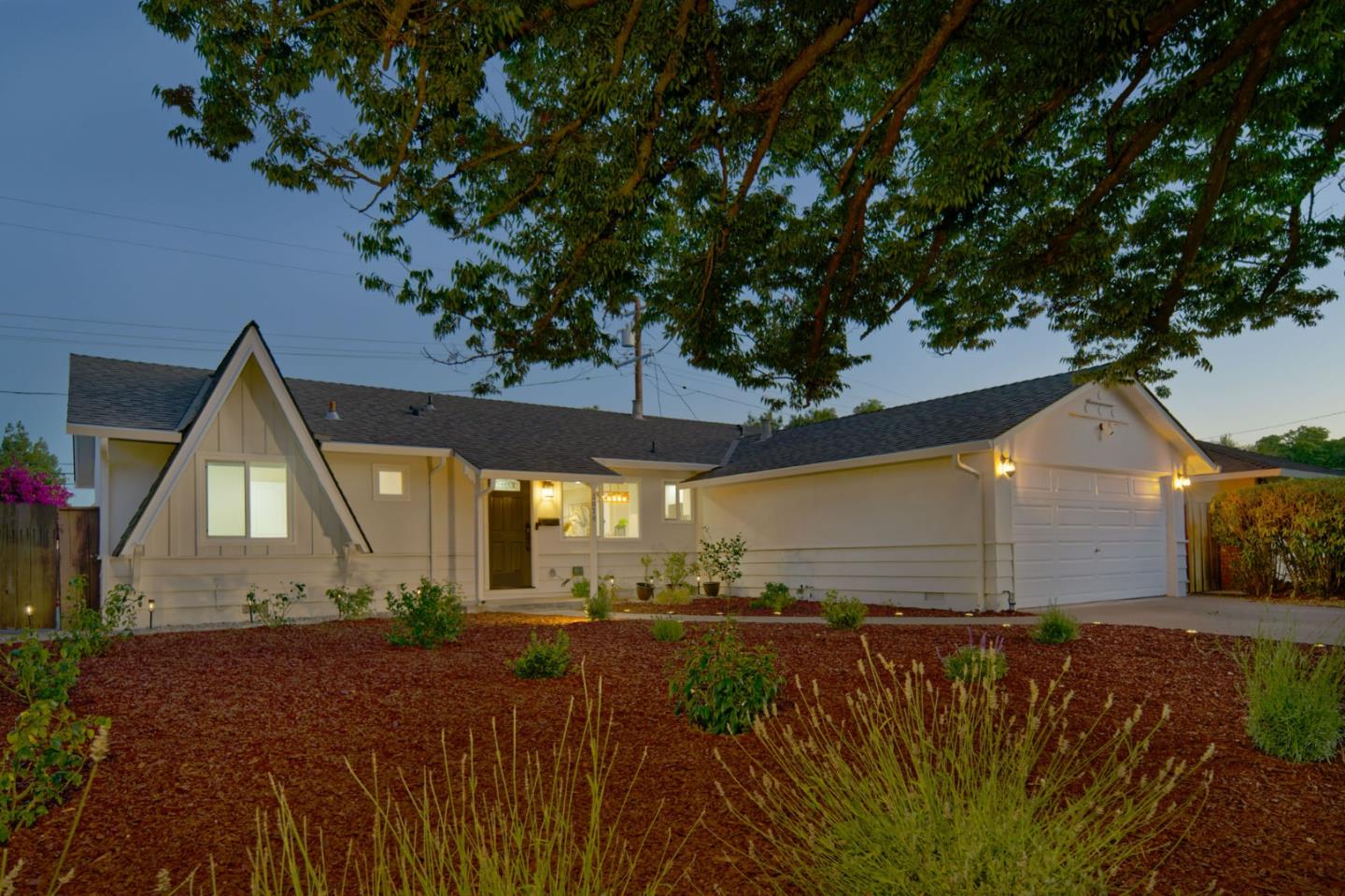 a front view of a house with a yard and mountain view