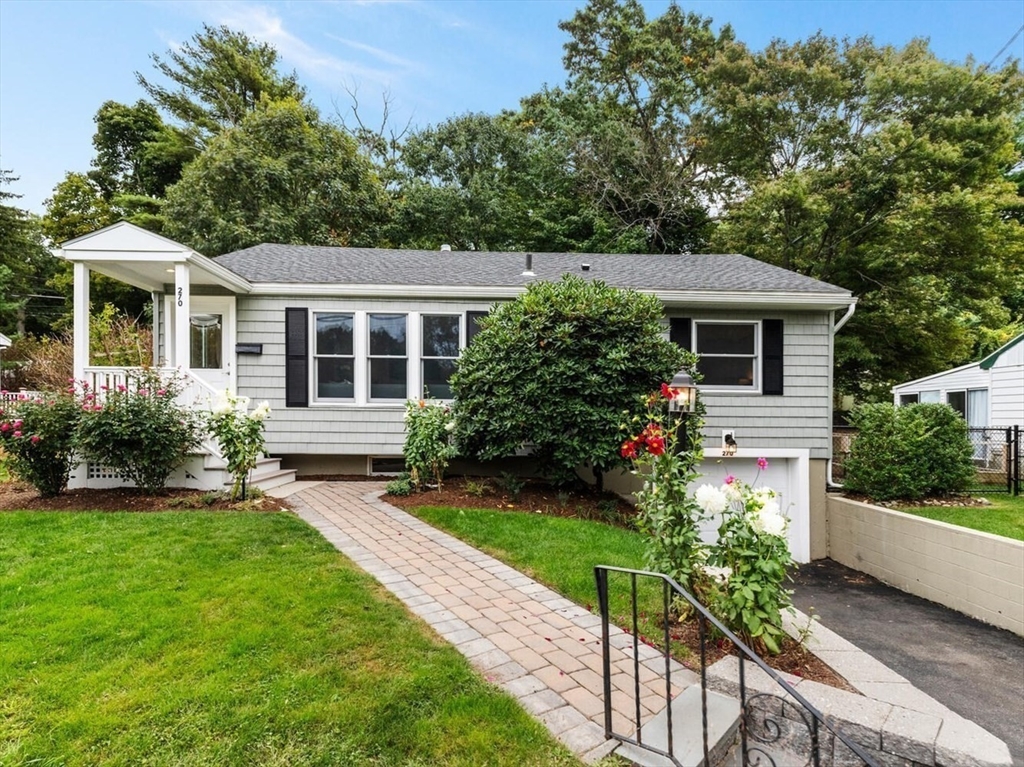 a front view of a house with a yard and potted plants