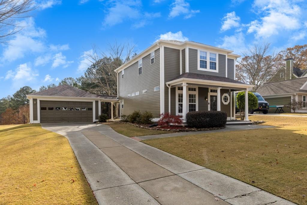 a front view of a house with yard and parking