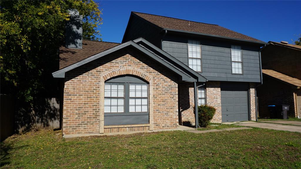 View of front of house with a garage and a front yard