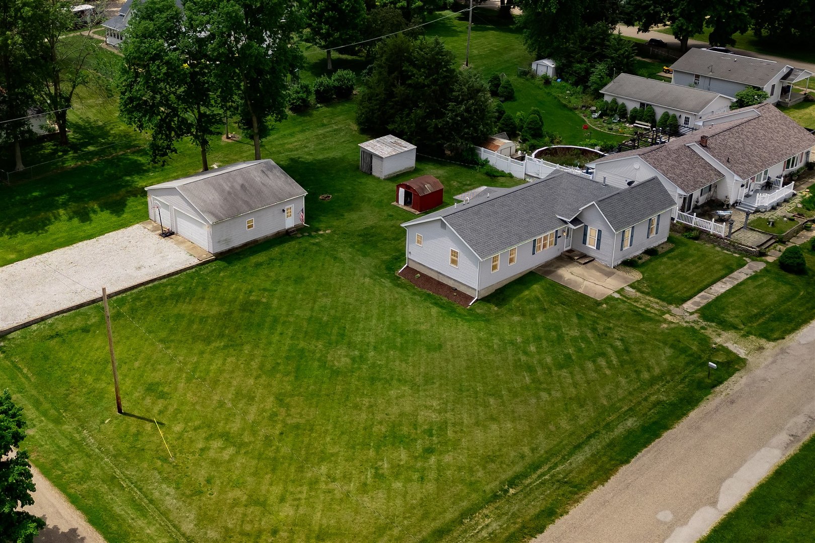 an aerial view of residential houses with outdoor space and trees all around