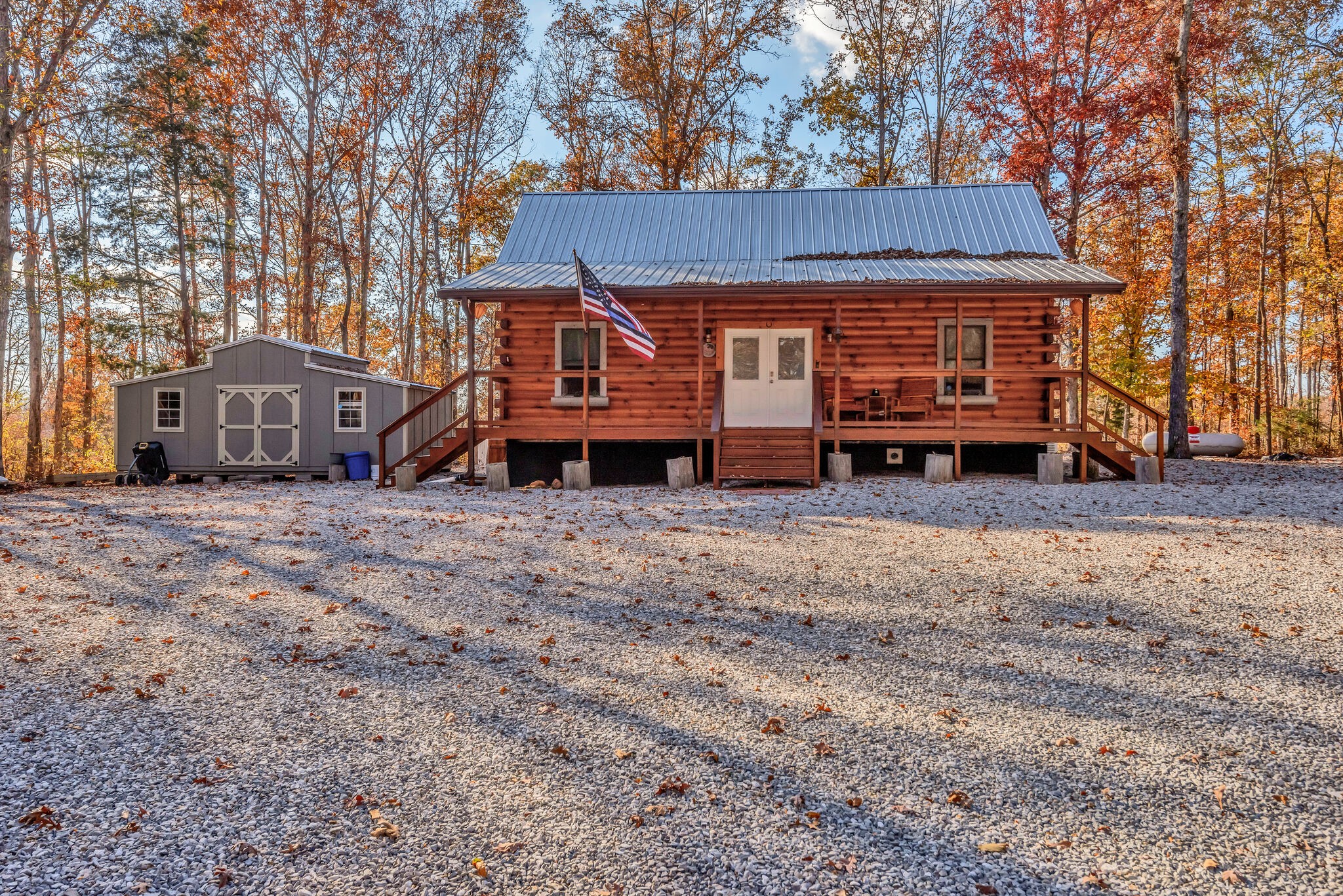 a view of a house with a yard and deck area under a large tree