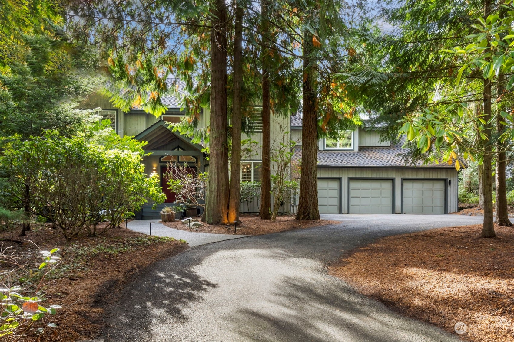 a front view of a house with a garden and tree