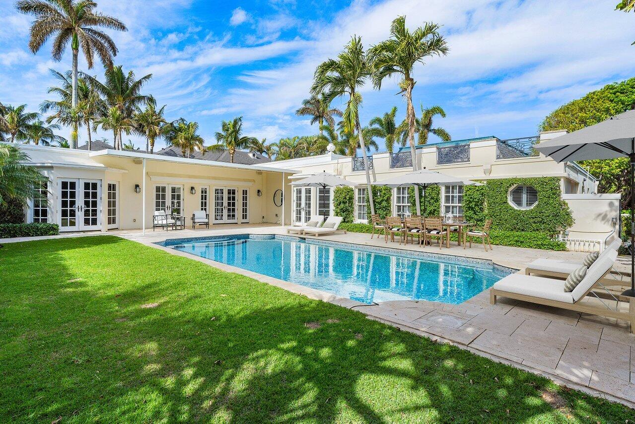 a view of a house with a swimming pool and sitting area