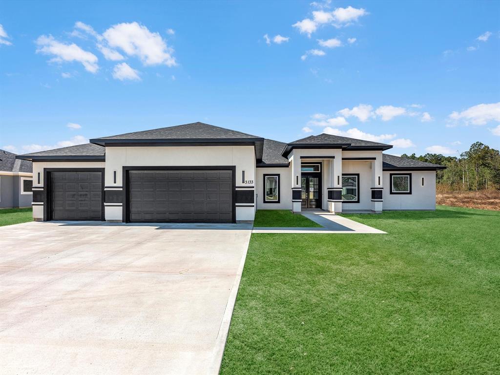 a front view of a house with a yard and garage