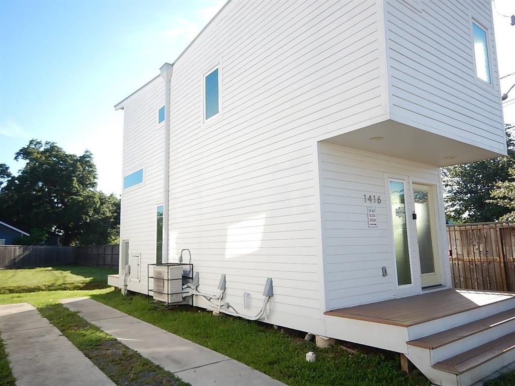 a view of a white house next to a yard