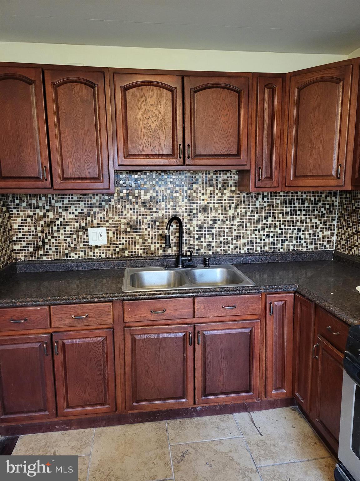 a kitchen with stainless steel appliances granite countertop wooden cabinets a sink and dishwasher