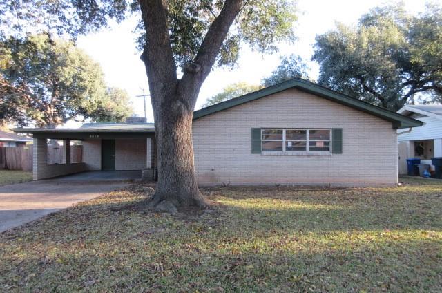 a view of a house with a large tree and a yard