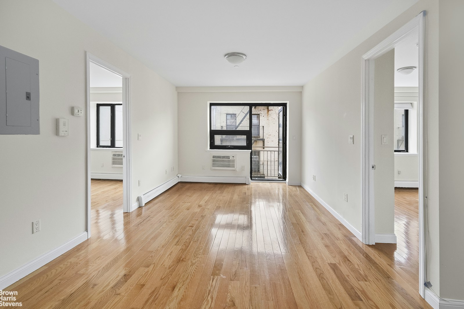 an empty room with wooden floor and windows