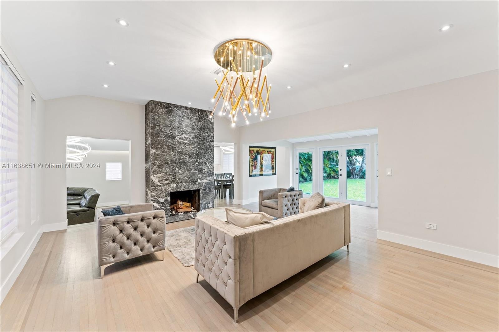 a living room with furniture a fireplace and a chandelier