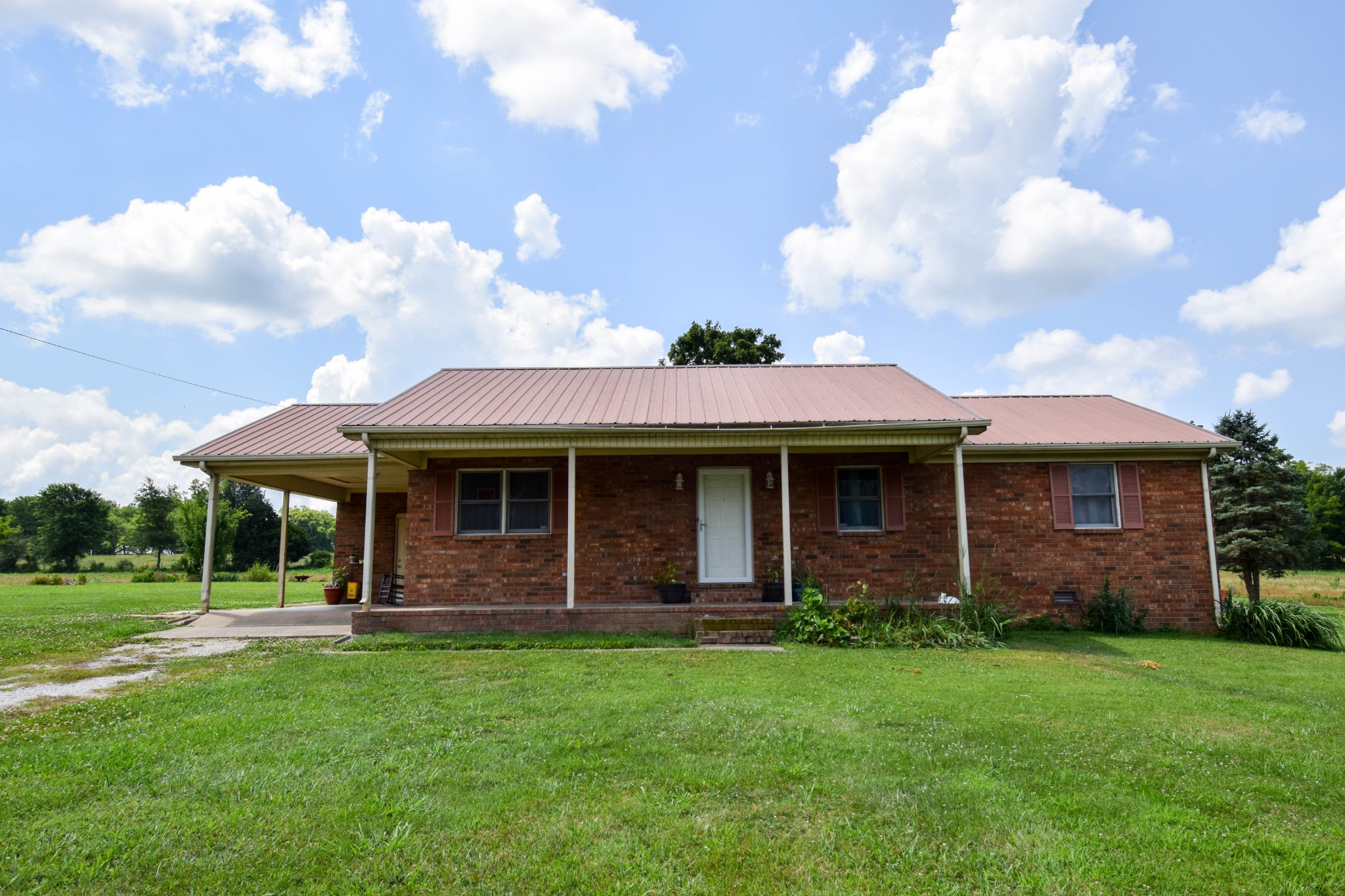 a view of a house with brick walls and a yard