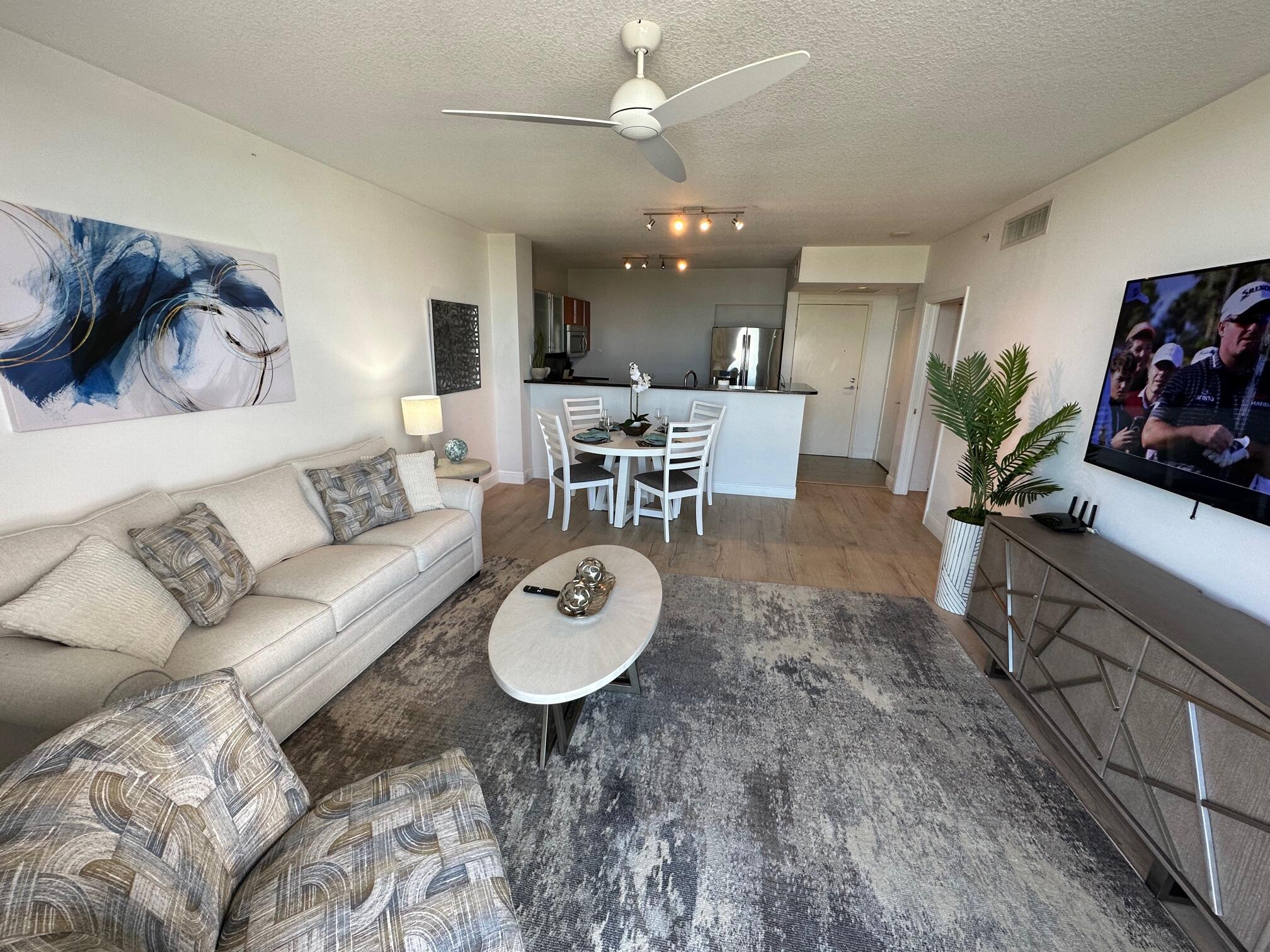 a living room with furniture and a dining table with wooden floor