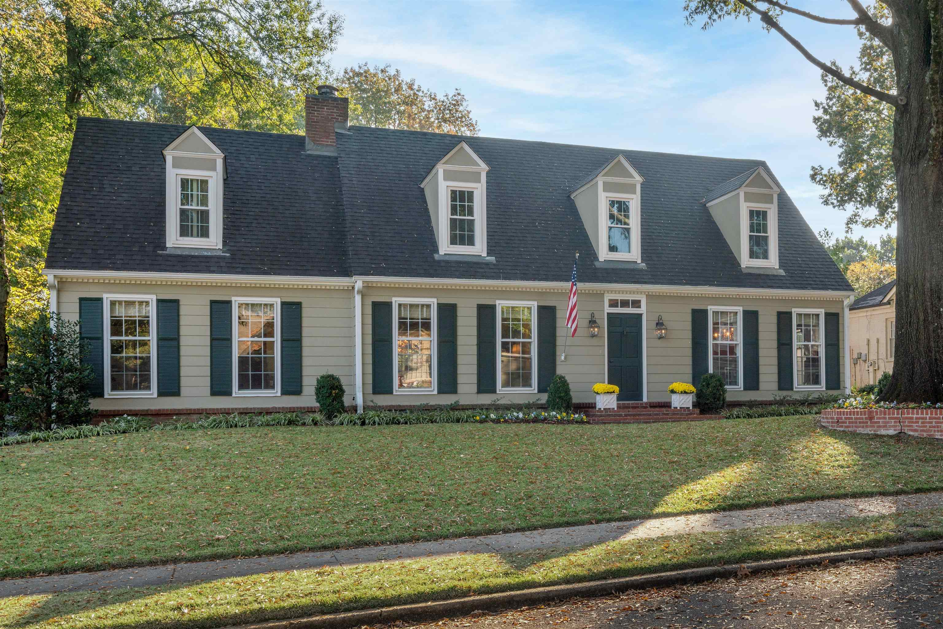 Cape cod home featuring a front lawn