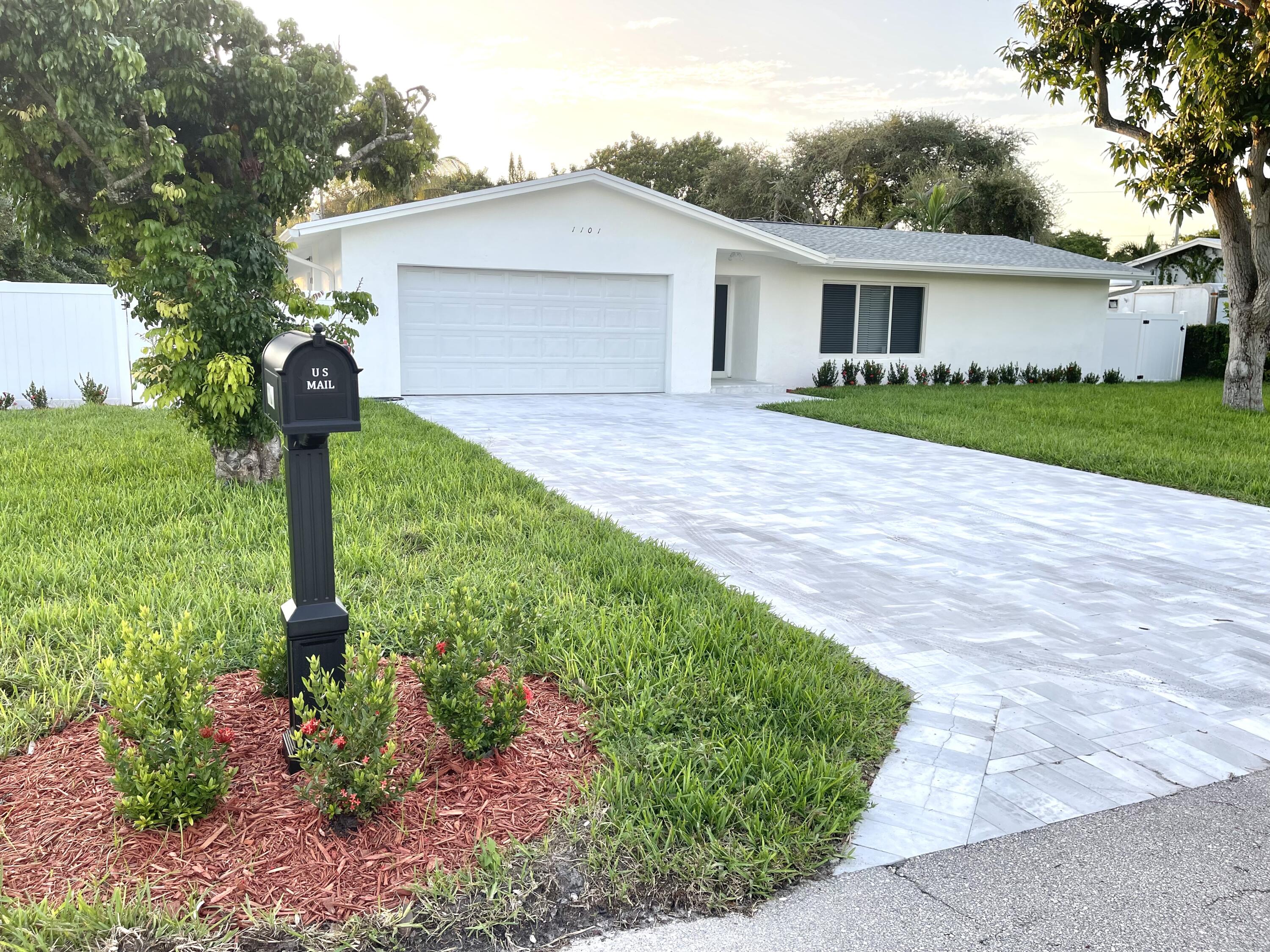 a front view of a house with a yard and fountain