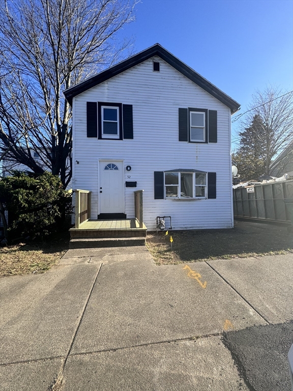 a view of a house with a yard and large tree