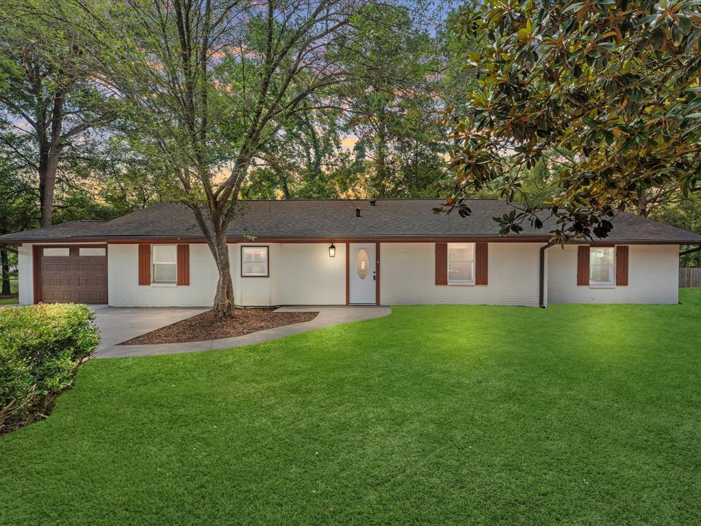 a front view of a house with a yard and trees