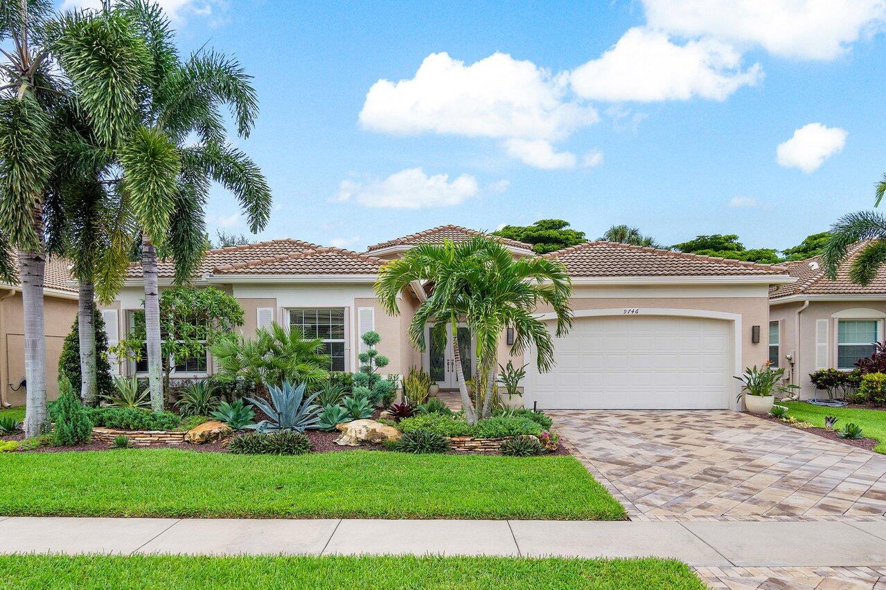 a front view of a house with a garden and yard