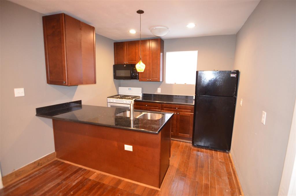 a kitchen with stainless steel appliances granite countertop a refrigerator a sink and a stove