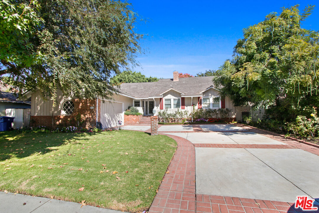 a front view of a house with yard and green space