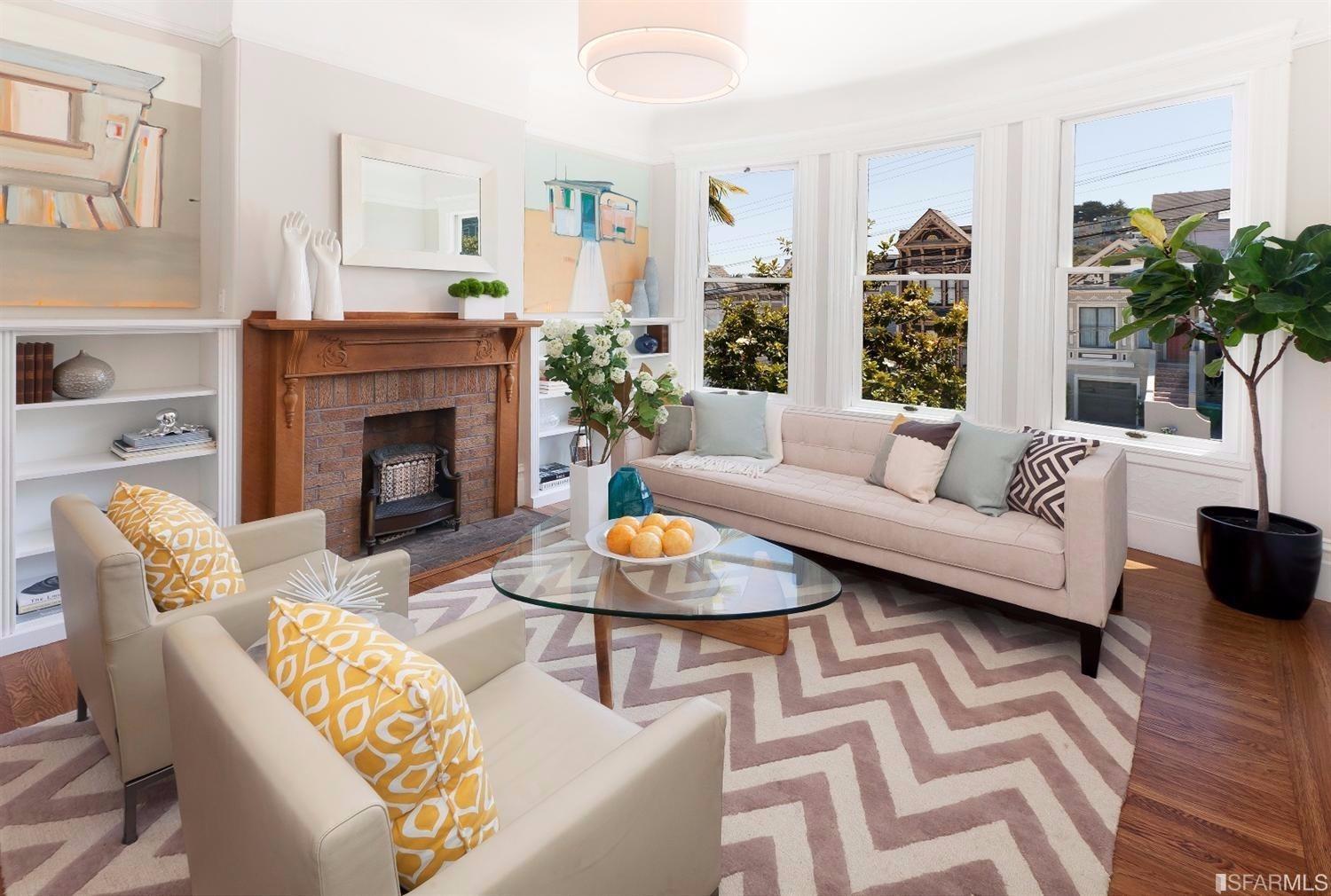 The living room is has built in bookcases, decorative firplace and mantel, high ceilings, and a view of downtown.