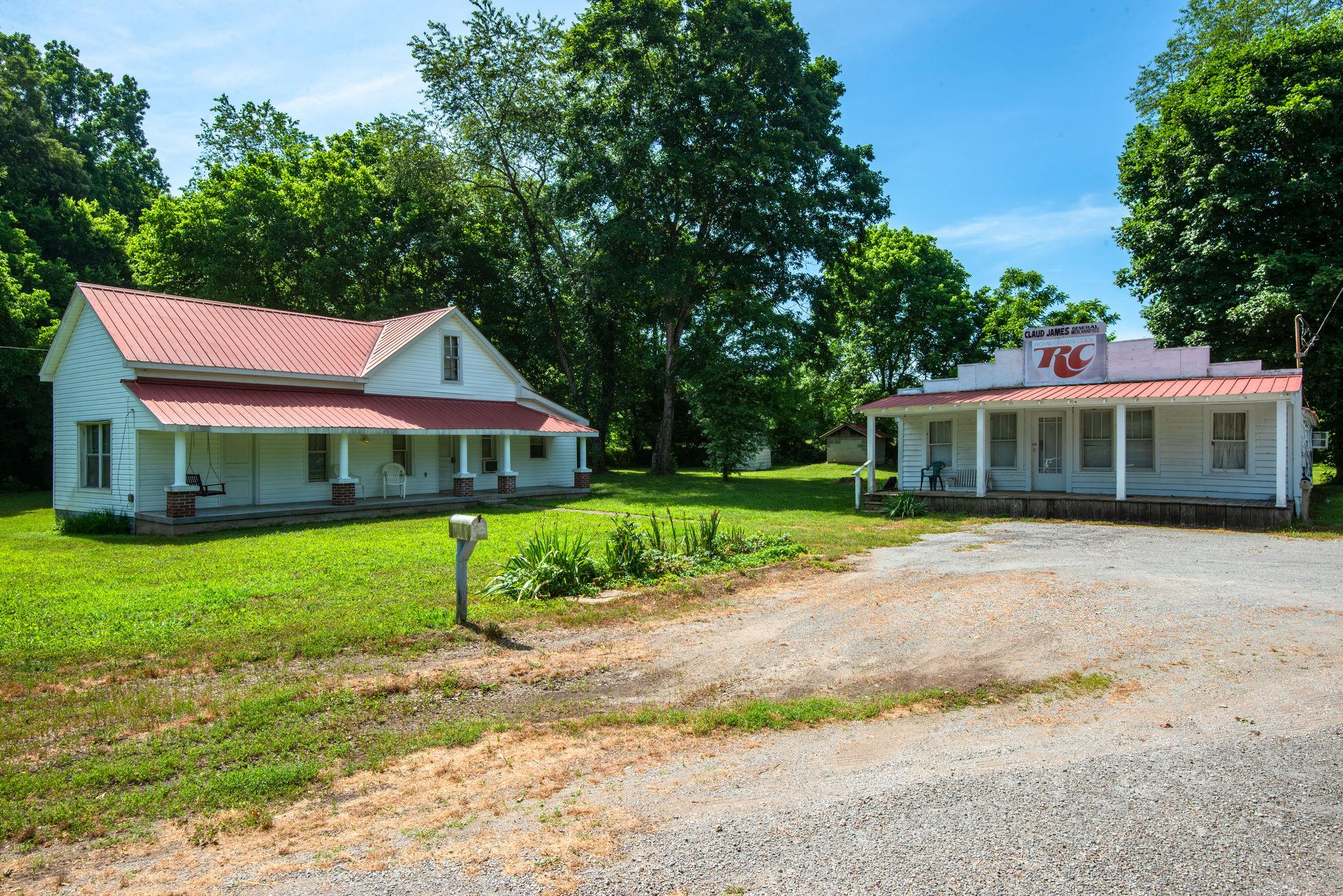 a front view of a house with a garden and trees